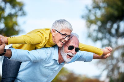 Nevető idős pár, a néni a bácsi hátán